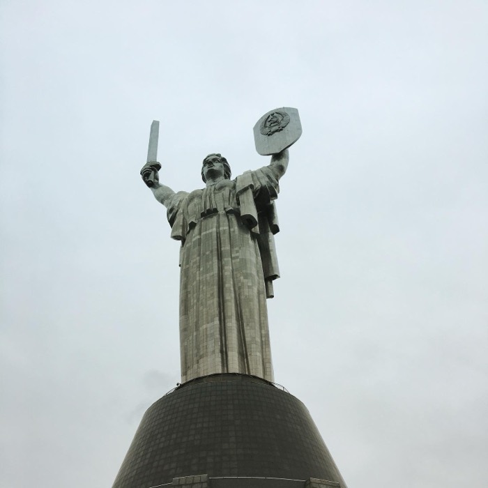 Motherland Monument with Soviet shield, low-angle brutalism post