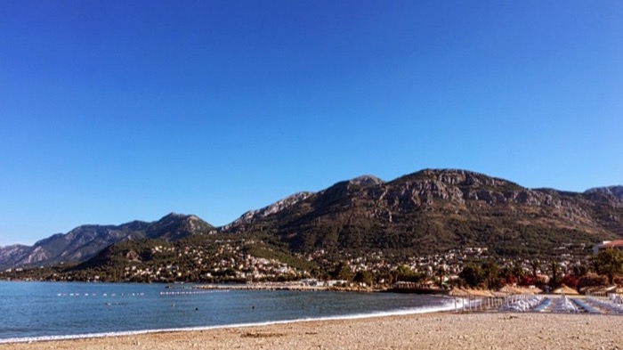 Pebble beach, sea and hillside town on Montenegrin coast (rotated)