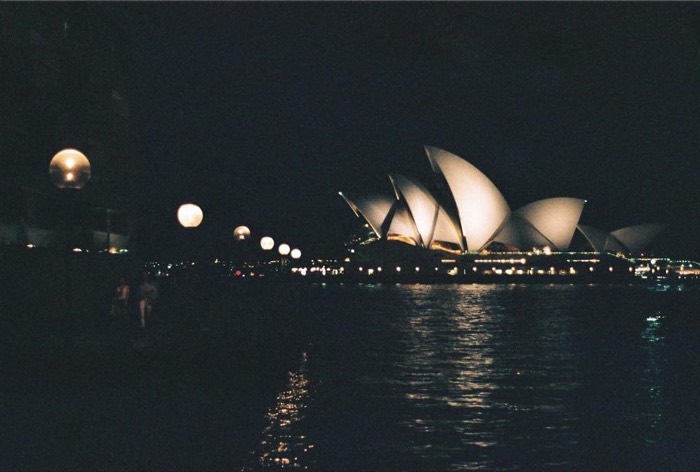 Sydney Opera House lit at night across dark harbour, 35mm film