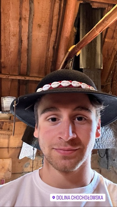Joshua: selfie in traditional Goral highlander hat inside wooden hut