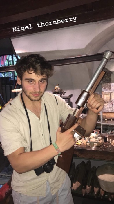 Joshua: posing with antique rifle in Istanbul antique shop, camera slung
