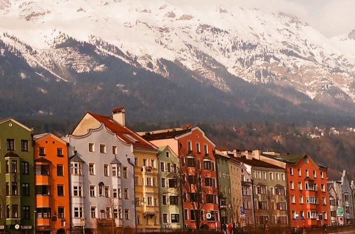 Colorful riverside houses under snowy Alps, classic Innsbruck 35mm shot