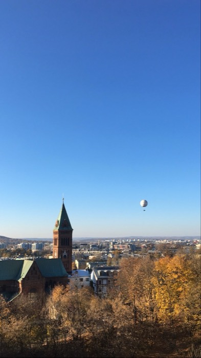 Autumn Krakow skyline: church spire and sightseeing balloon over golden trees