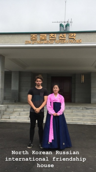 Joshua: posing with guide in pink hanbok at Korea-Russia Friendship House