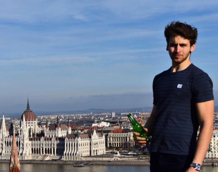 Joshua: posing with beer bottle above Danube, Hungarian Parliament behind