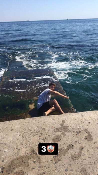 Joshua: sprawled on pier edge over Black Sea surf, step 3 of saga