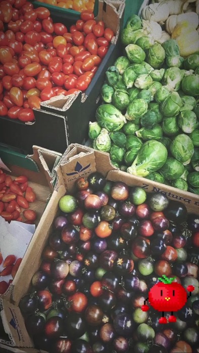 Market crates of tomatoes, brussels sprouts and dark heirloom tomatoes