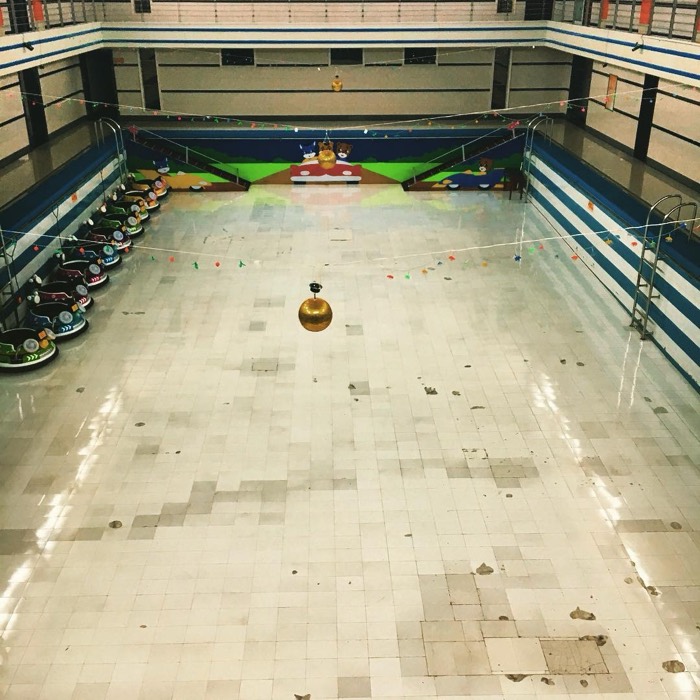 Drained swimming pool converted into bumper-car arena with disco ball