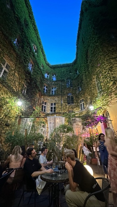 Evening drinks with friends in ivy-covered tenement courtyard bar