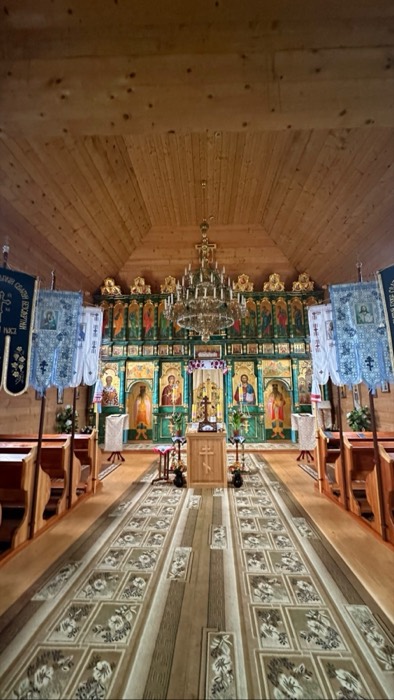 Wooden Orthodox church interior with iconostasis and chandelier