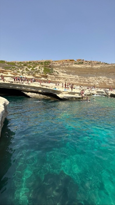 Crowds swimming at St Peter's Pool rock shelf, clear turquoise water