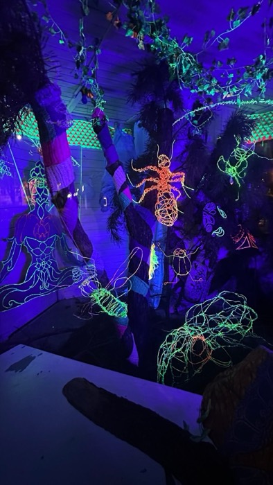 UV blacklight art room, glowing wire spider and jellyfish sculptures