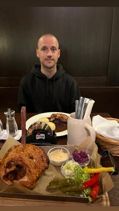 Friend with roast pork knuckle feast at Pilsner Urquell restaurant