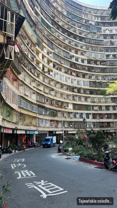 Curved circular Guomao housing estate towering over street, dense balconies