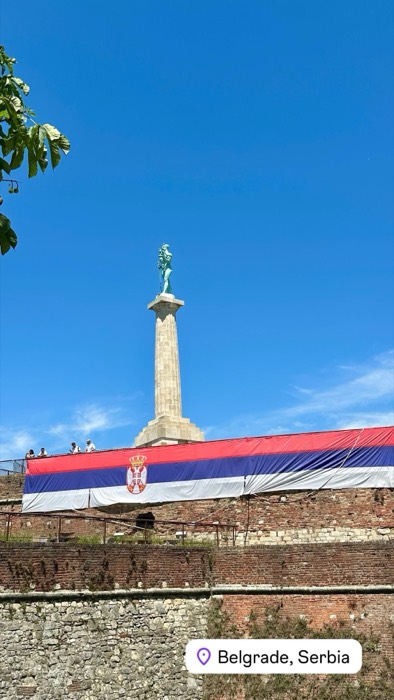 Pobednik monument above fortress wall draped with giant Serbian flag