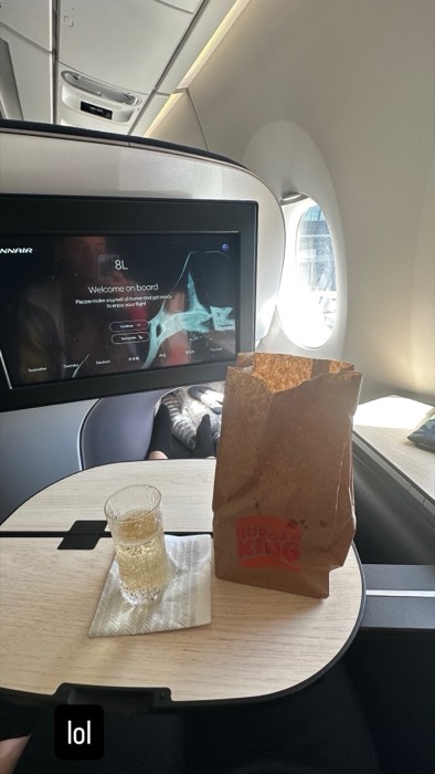 Finnair business class champagne next to Burger King bag