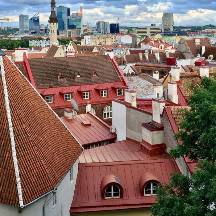 Red-tiled old-town rooftops against modern skyline from viewing platform