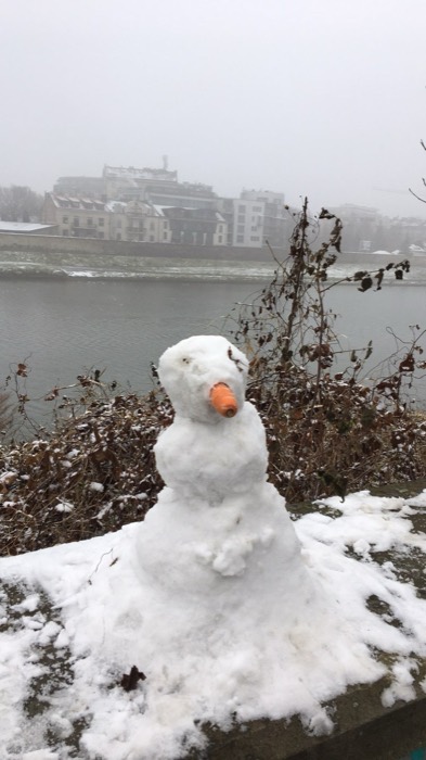 Carrot-nosed snowman on foggy Vistula riverbank, winter Krakow