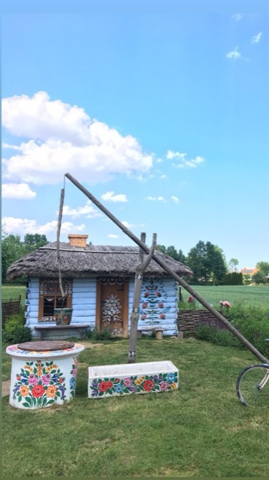Blue thatched cottage with painted folk flowers and well sweep, Zalipie