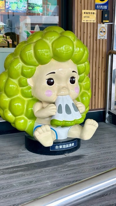 Cute custard-apple baby mascot statue outside farmers association shop
