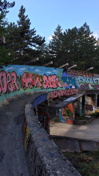 Abandoned graffiti-covered 1984 Olympic bobsled track curving through Trebevic forest