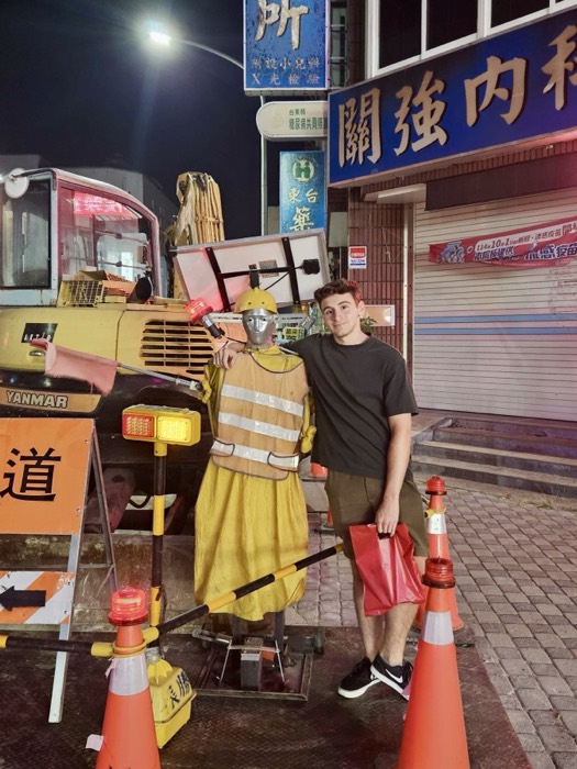 Joshua: posing with road-work safety mannequin on a night street