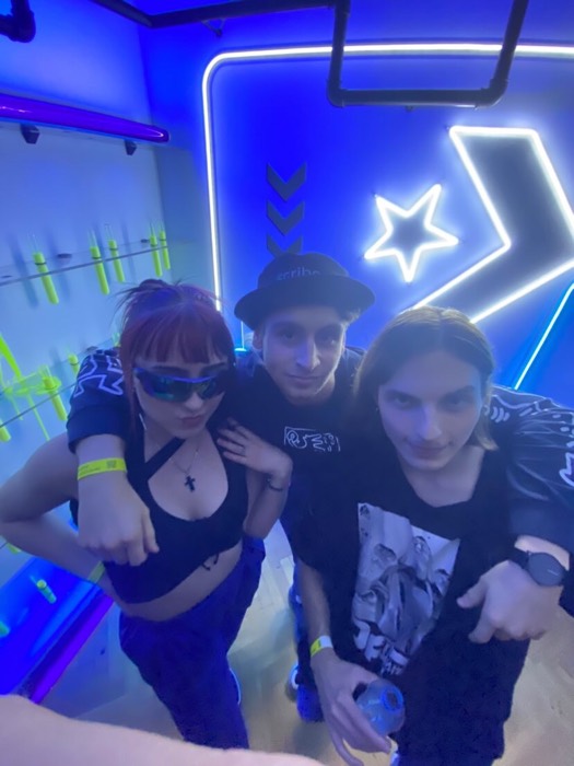 Joshua: with two friends posing in neon-lit club room