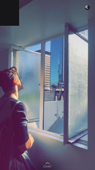 Joshua: Snapchat gazing out window at Melbourne skyscrapers.