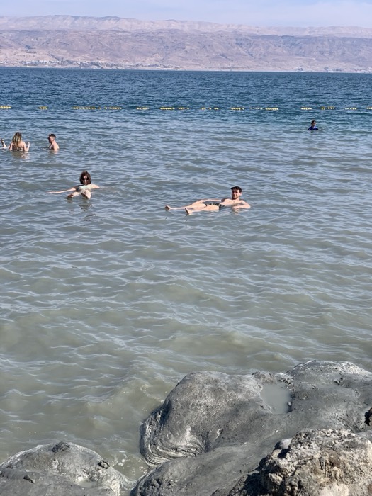 Joshua: floating effortlessly in the Dead Sea, mountains across the water