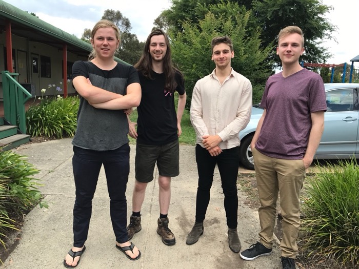 Four young guys posing outside suburban house, Australia group shot
