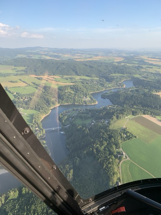 Aerial view of river, reservoir and bridge from helicopter window
