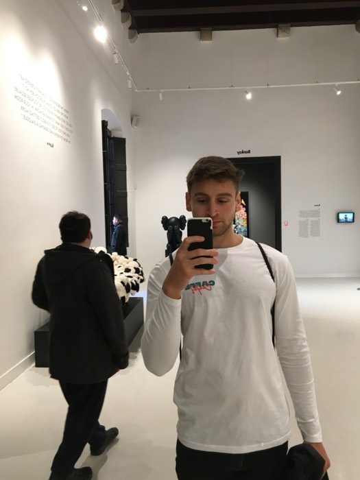 Joshua: mirror selfie in white-walled Banksy/Kaws art gallery