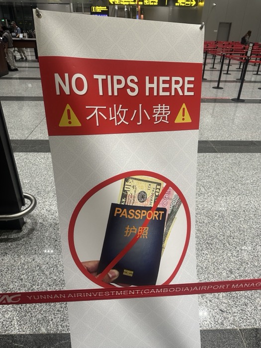 Quirky airport No Tips Here sign banning passport-with-cash bribes