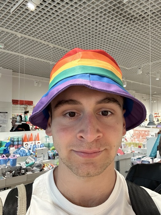 Joshua: selfie in rainbow bucket hat inside a Flying Tiger store