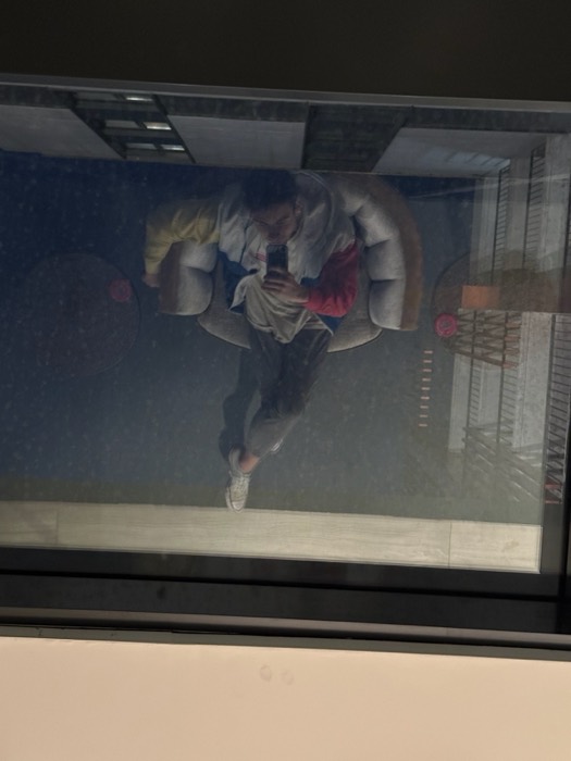 Joshua: reflected selfie in glass ceiling, retro varsity jacket