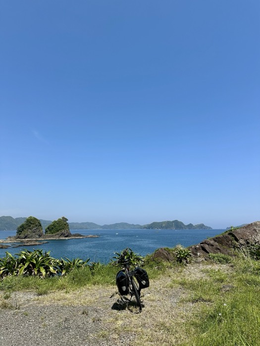 Loaded touring bike before blue coastal islets and grass