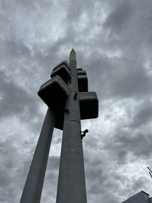 Zizkov TV Tower with crawling baby sculptures under grey sky