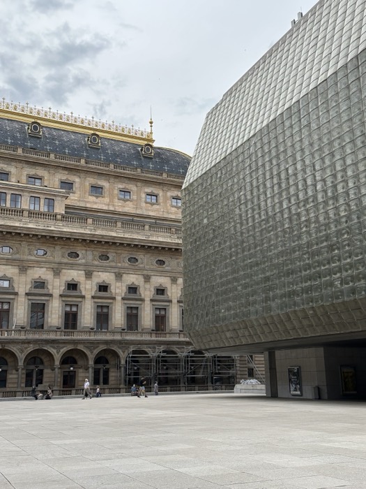 National Theatre gold roof beside Nova scena glass-brick building, striking contrast.