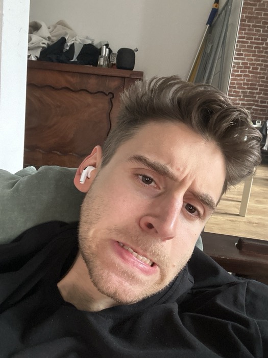 Joshua: tired close-up selfie with AirPods at home