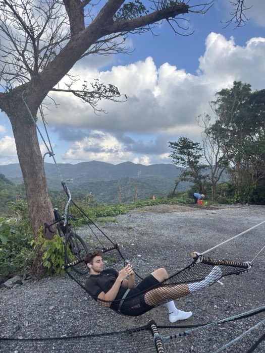 Joshua: lounging in hammock beside bike, mountain valley view
