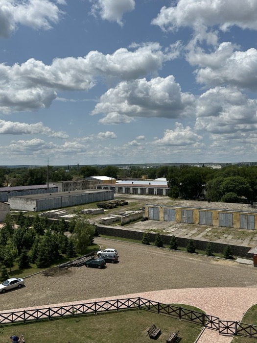 Hazy view from fortress tower over warehouses, car park and town