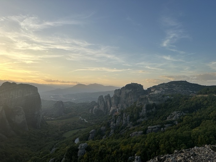 Meteora rock formations and monasteries at sunset, sweeping valley