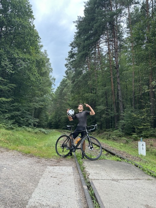 Joshua: posing with road bike on forest railway track, flexing