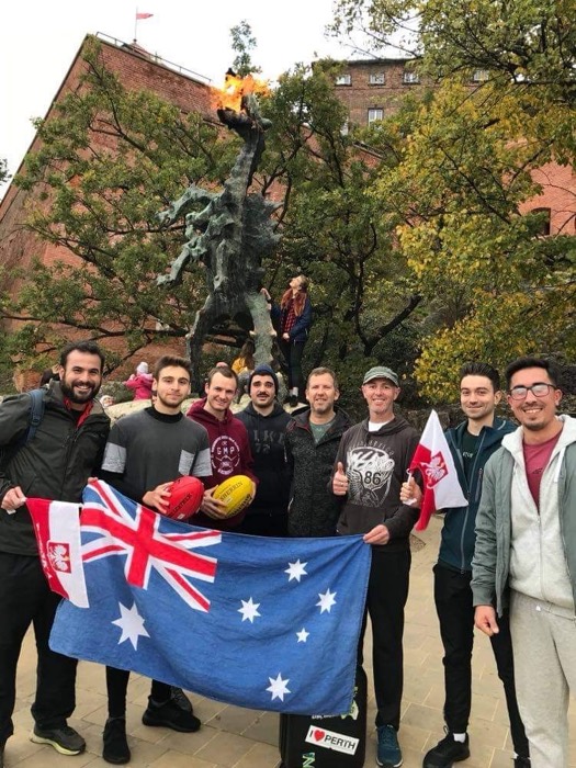 Aussie expats with AFL balls and flag at fire-breathing Wawel Dragon.