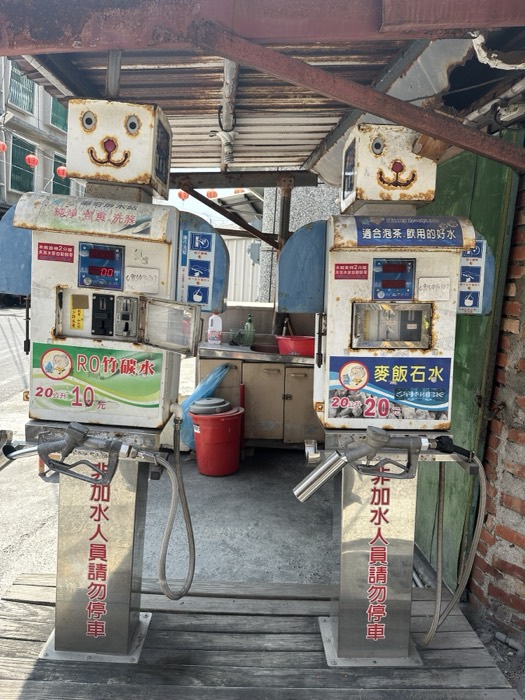 Quirky animal-faced water vending machines under a roadside shelter