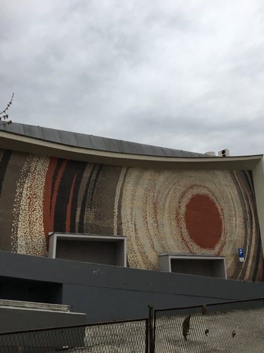 Modernist building with abstract circular tile mosaic facade