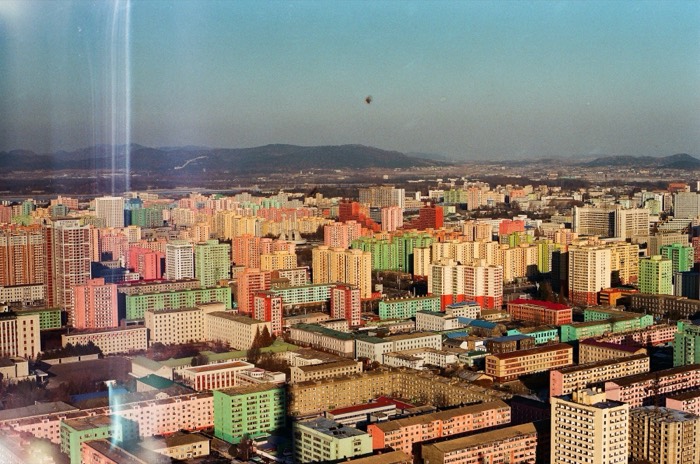 Pastel apartment blocks of Pyongyang skyline, film grain