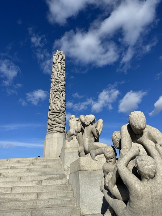 Vigeland Monolith and granite figure groups under blue sky