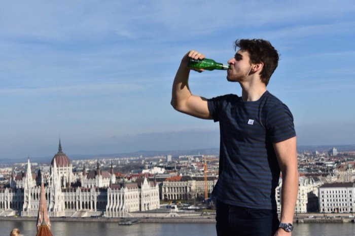 Joshua: drinking beer above Danube, Hungarian Parliament behind