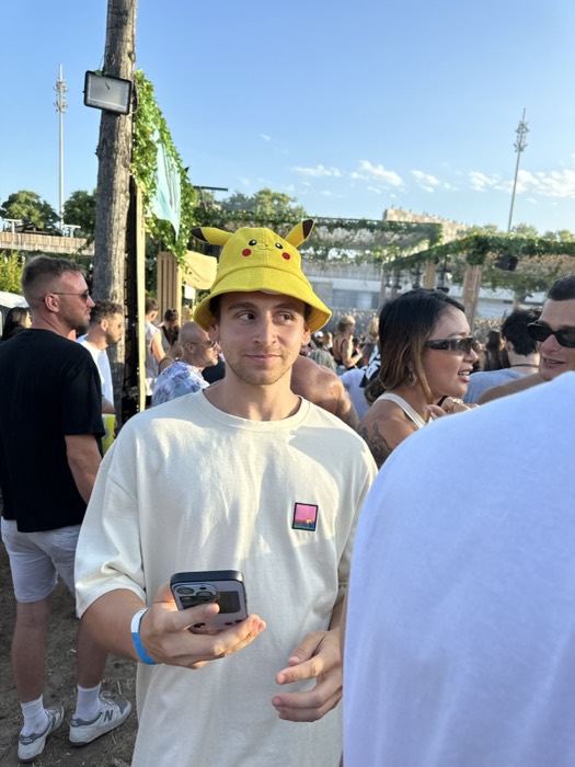 Joshua: in Pikachu bucket hat at crowded daytime festival party